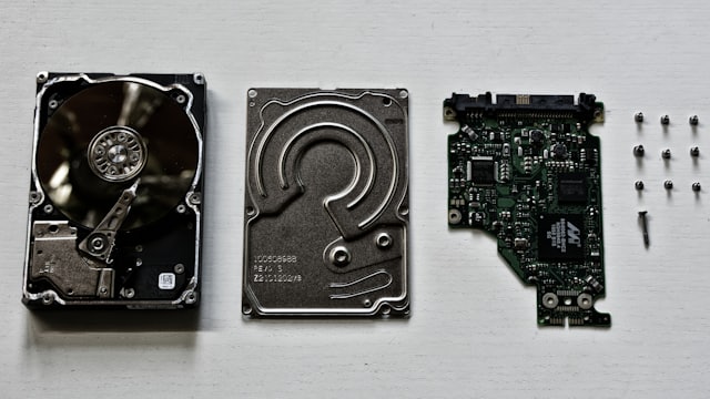 Peças de um disco rígido desmontado sobre fundo claro