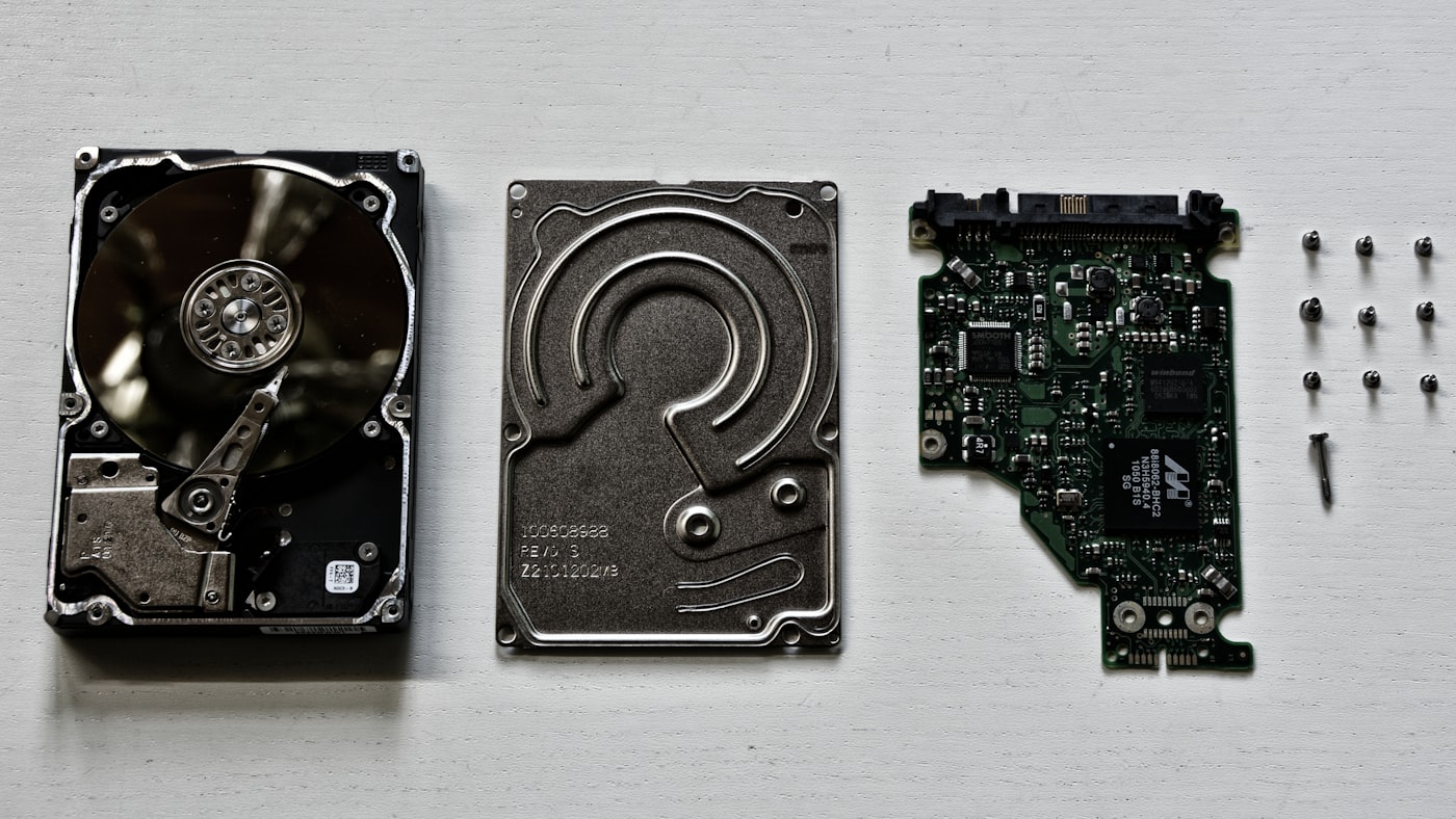 Peças de um disco rígido desmontado sobre fundo claro